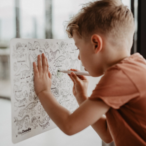 Boy colouring in Hey Doodle DinoRoar Colouring mat.